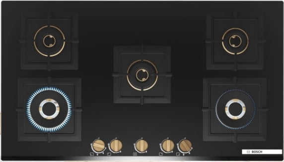 Bosch PNV9B6G20I five burner gas hob top view with two burners lit and brass-finish knobs along the front