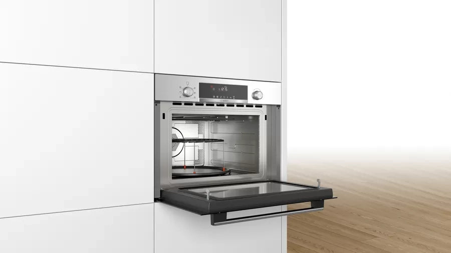 Bosch CMA585MS0 built-in microwave oven with open door showing the cavity, rack and control panel