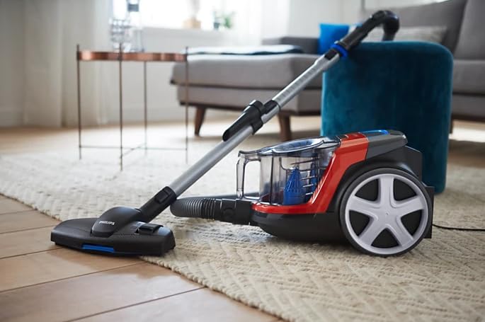 Philips PowerPro Compact FC9351/01 vacuum cleaner cleaning a rug in a living room