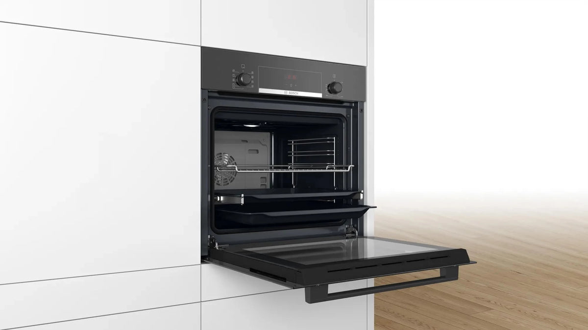 Bosch HBJ534EB0I built into a white cabinet with door open, showing wire rack and two trays