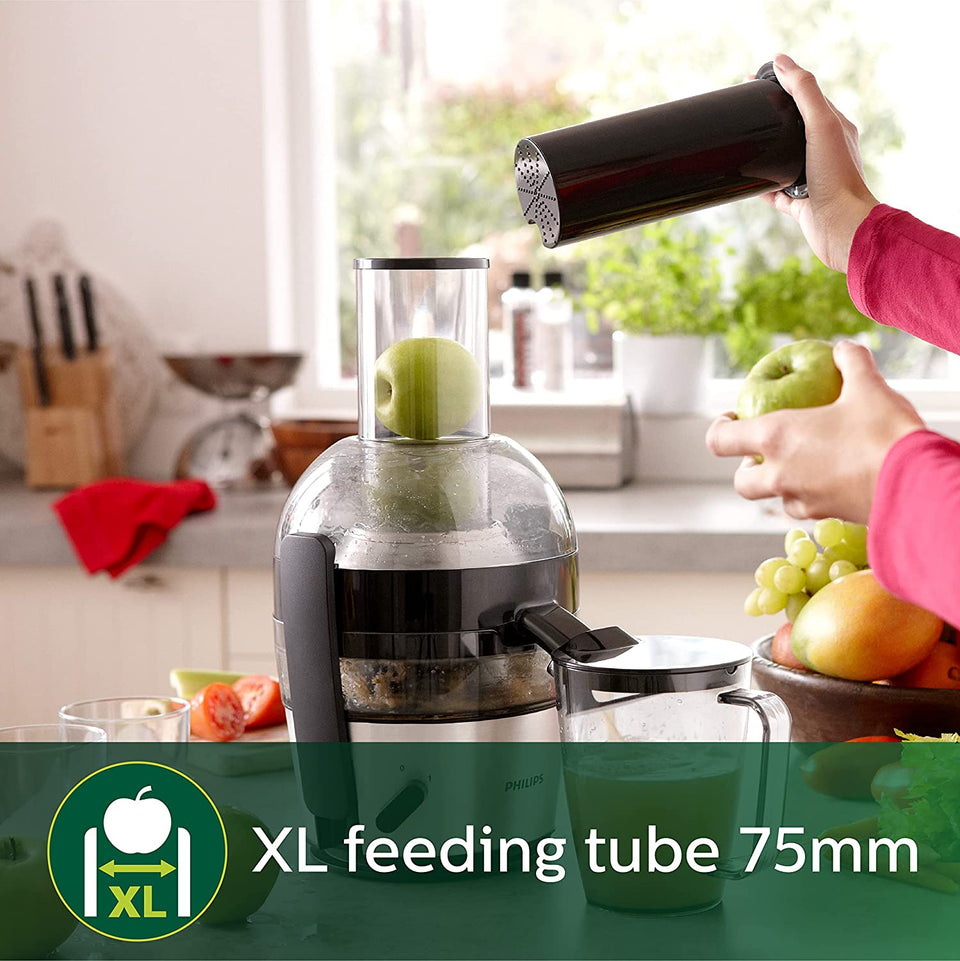 Philips HR1863/20 juicer with a whole apple in the 75 mm XL feeding tube and a jug of green juice on a kitchen counter