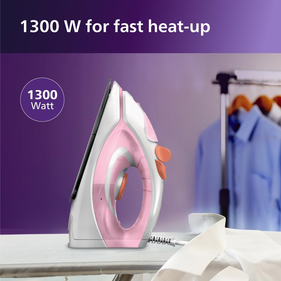 Philips GC1920/28 pink steam iron standing on an ironing board with shirts hanging behind