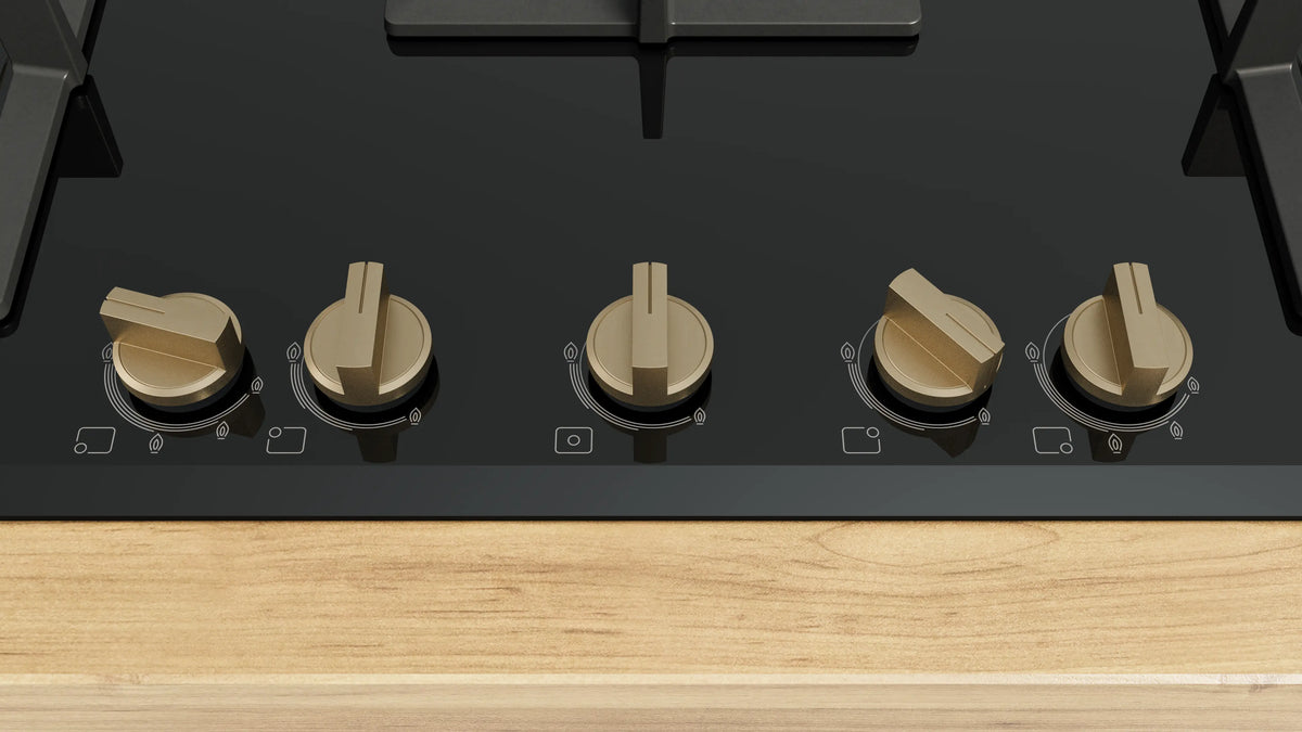 Close-up of the five brass-finish control knobs and flame markings on the Bosch PNV9B6G21I gas hob