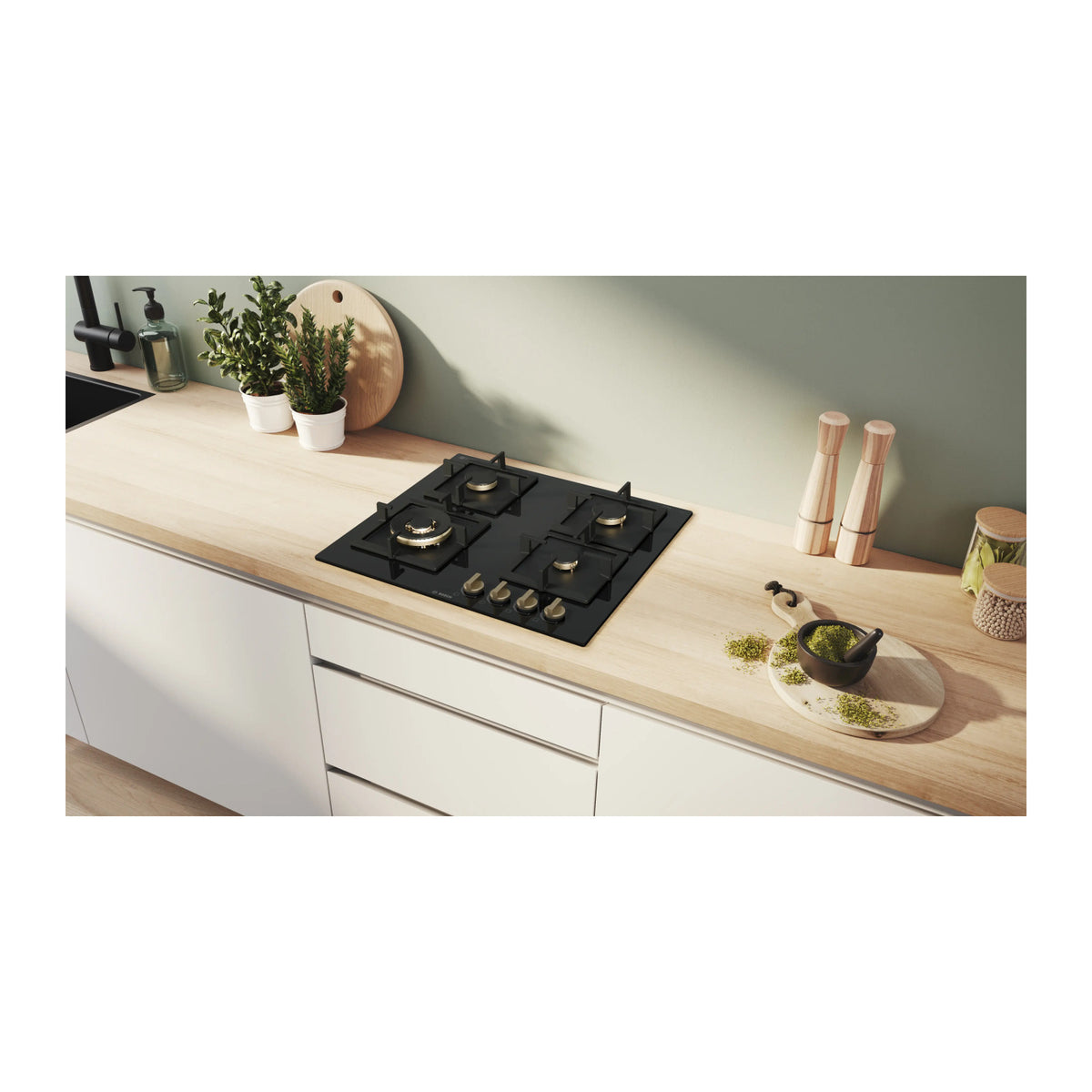 Bosch PNH6B6F21I black glass 4 burner gas hob built into a wooden kitchen worktop