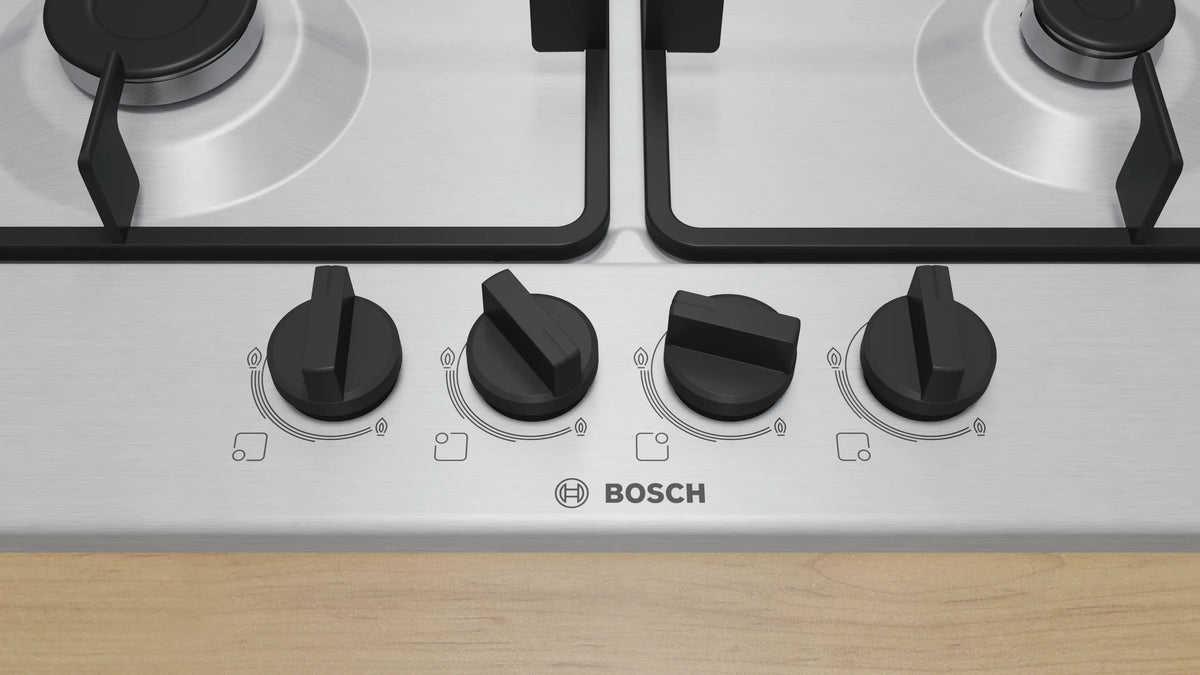 Close-up of the four black control knobs and Bosch logo on the PGH6B5K60I gas hob