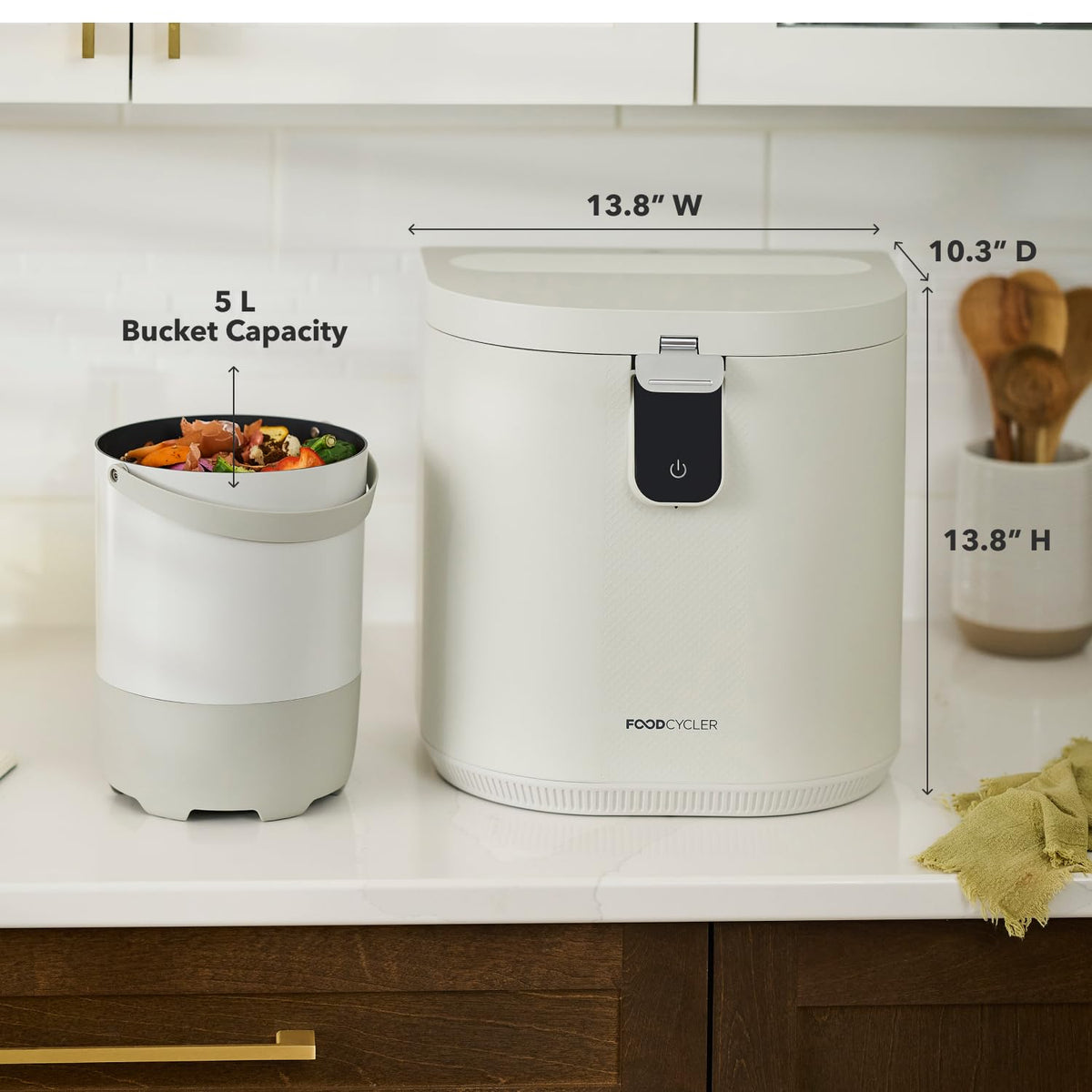 FoodCycler ECO 5 on a kitchen counter beside its 5 L bucket of scraps, with 13.8 inch width and height and 10.3 inch depth marked