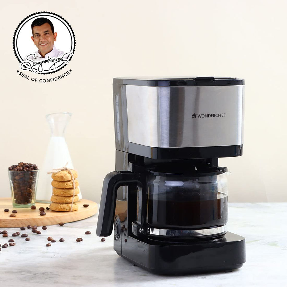 Wonderchef Regalia Pronto Brew 63154572 coffee maker on a kitchen counter with coffee beans, biscuits and a milk carafe, with Sanjeev Kapoor Seal of Confidence