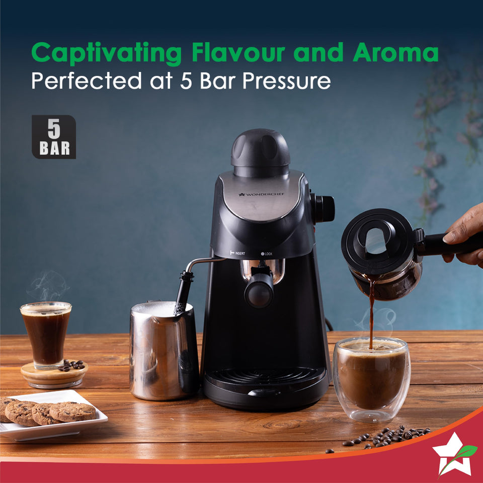 Wonderchef Regenta 63154851 espresso machine with 5 bar badge, steel milk jug and coffee being poured from the carafe