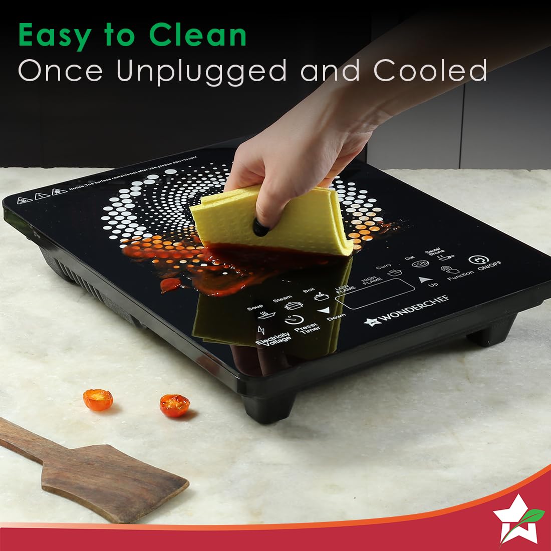 Wiping a spill off the glass top of the Wonderchef 63152875 induction cooktop with a yellow cloth