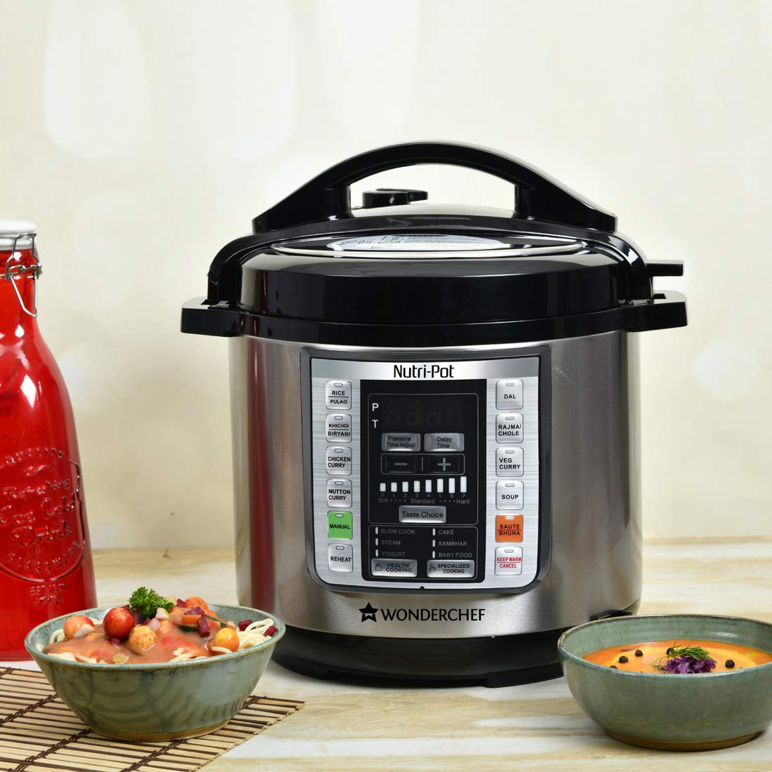 Wonderchef Nutri-Pot 63152847 electric pressure cooker on a counter with bowls of pasta and soup beside it