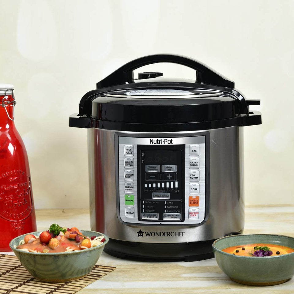 Wonderchef Nutri-Pot 63152847 electric pressure cooker on a counter with bowls of pasta and soup beside it