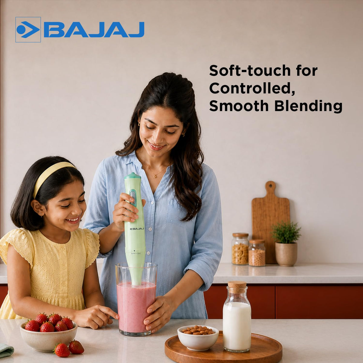 Mother and daughter blending a strawberry smoothie with the Bajaj HB 20 hand blender