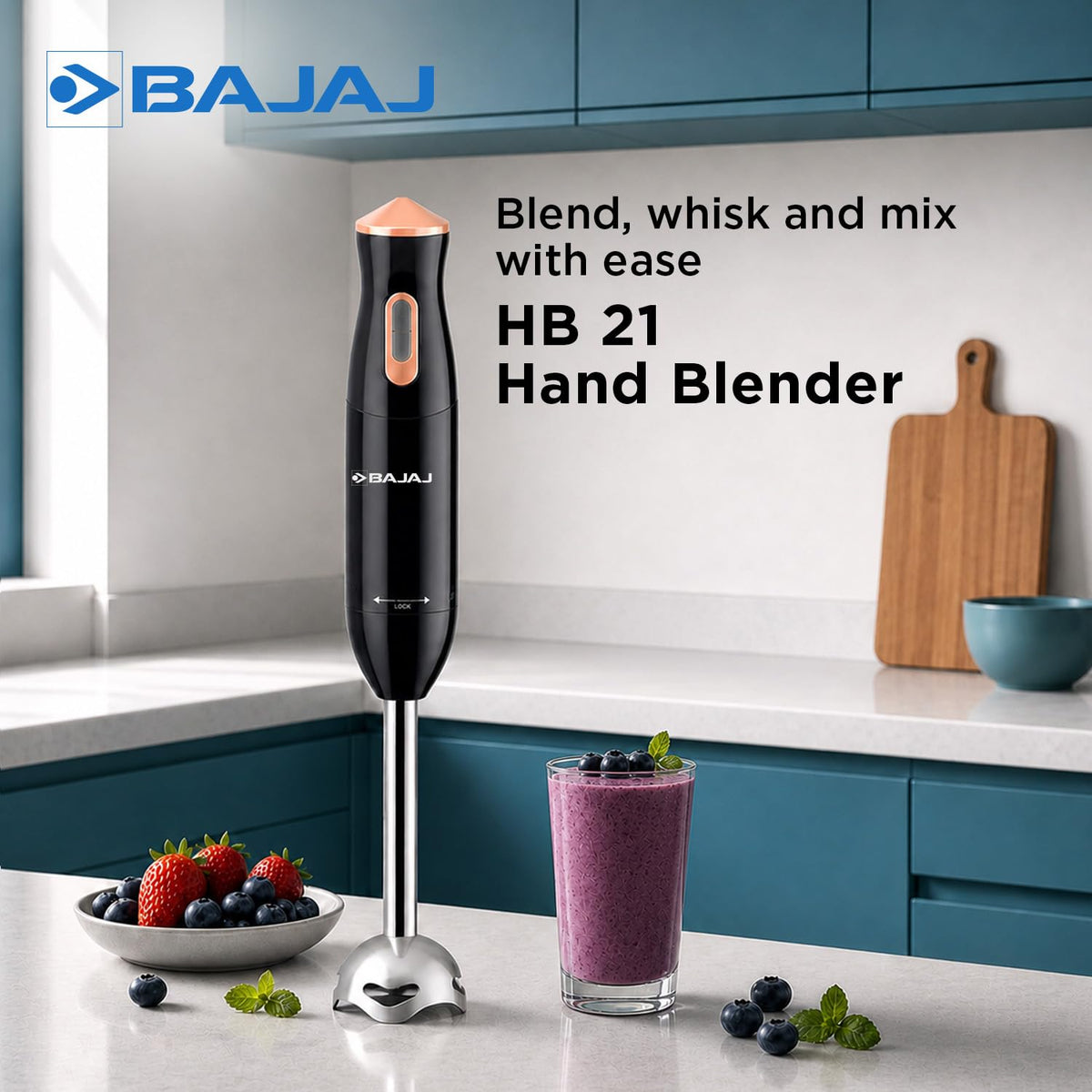 Bajaj HB 21 hand blender standing on a kitchen counter beside a berry smoothie and a bowl of fruit