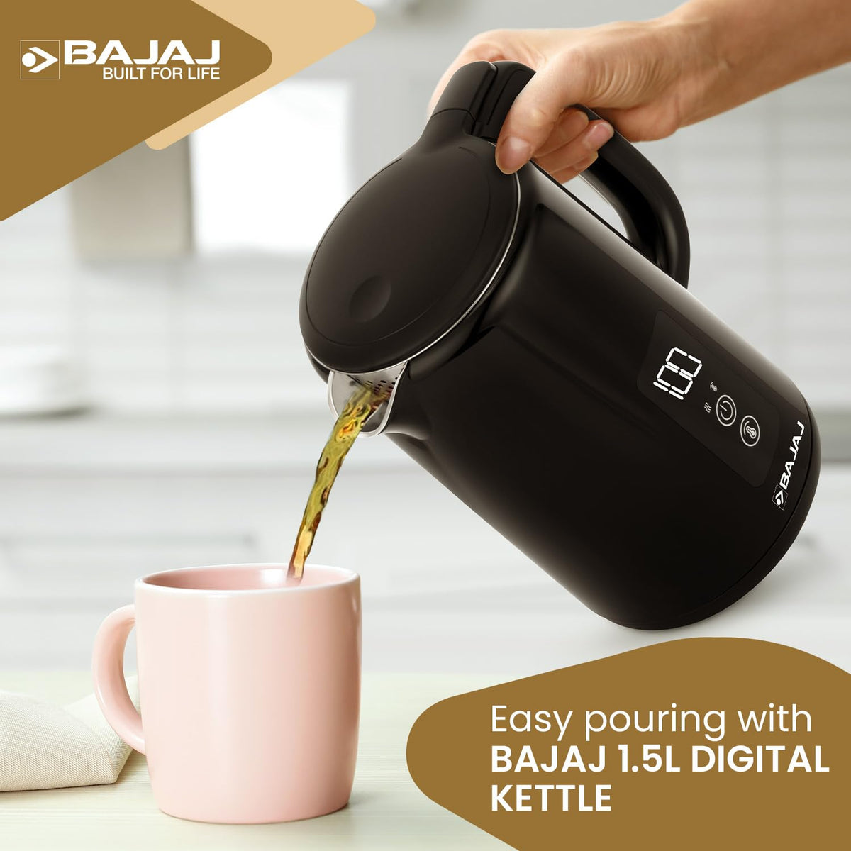 Hand pouring tea from the Bajaj KTP 1.5 Digital kettle into a pink mug through its spout