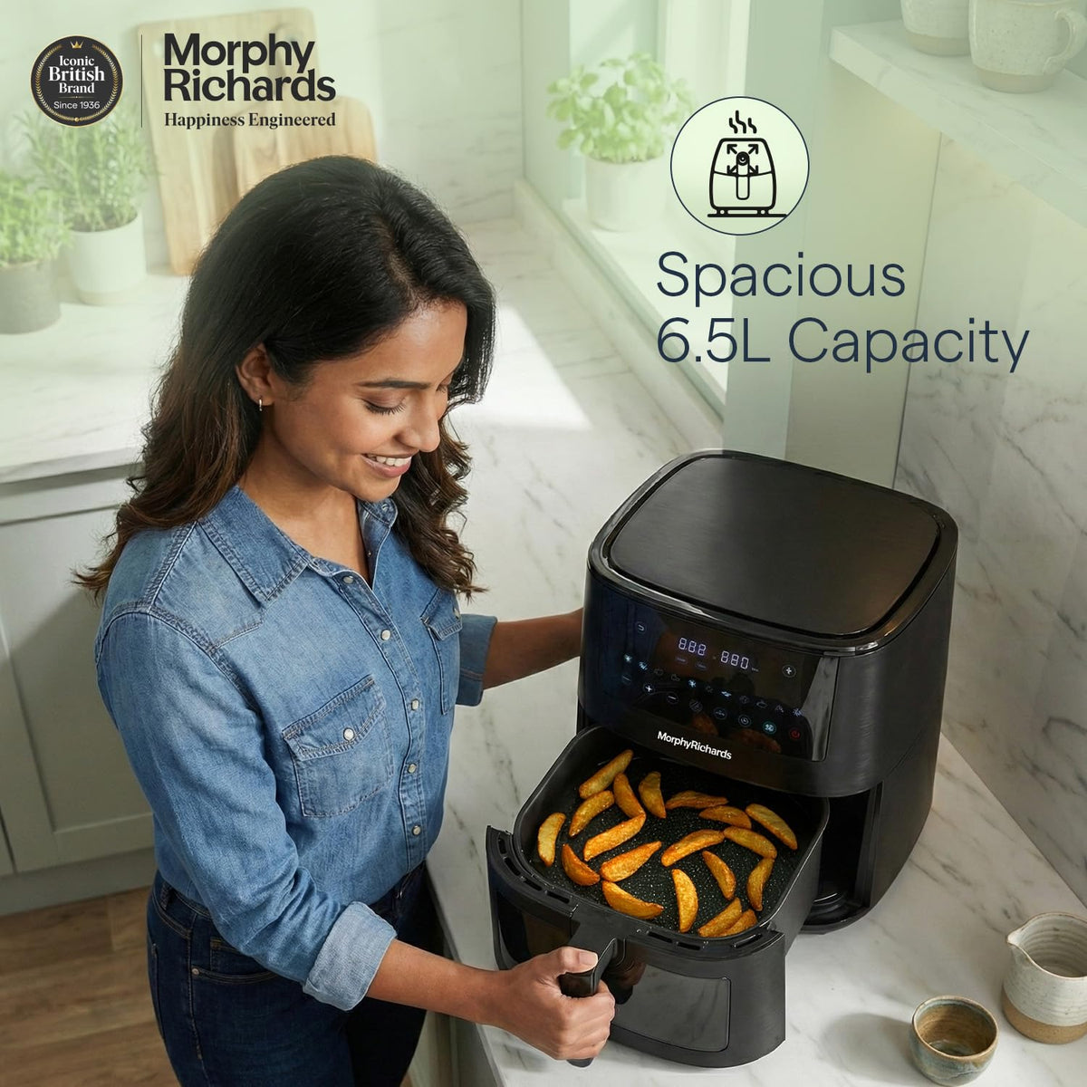 Woman with the Morphy Richards 510064 air fryer basket open showing potato wedges, highlighting the 6.5 L capacity