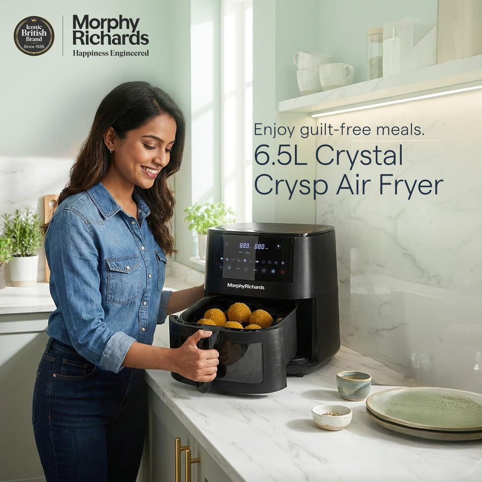 Woman taking golden snacks from the basket of the Morphy Richards 510064 6.5 L Crystal Crysp air fryer in a kitchen