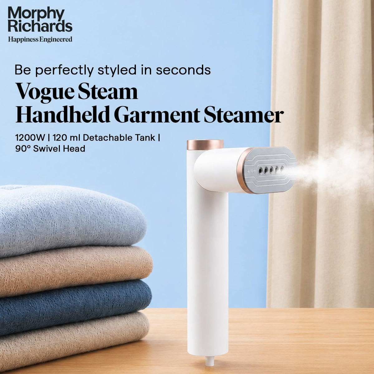 Morphy Richards Vogue Steam 1200W garment steamer releasing steam beside folded towels, with 1200W, 120 ml detachable tank and 90° swivel head text