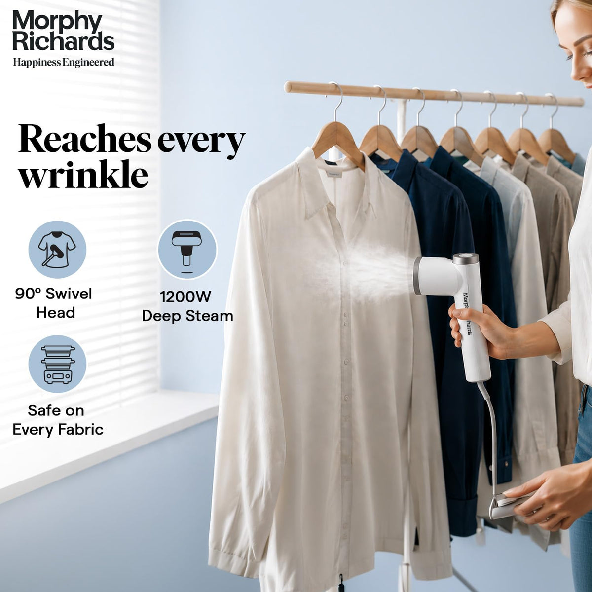 Woman steaming a shirt on a hanging rail with the Morphy Richards Vogue Steam 1200W garment steamer, with 90° swivel head and 1200W callouts