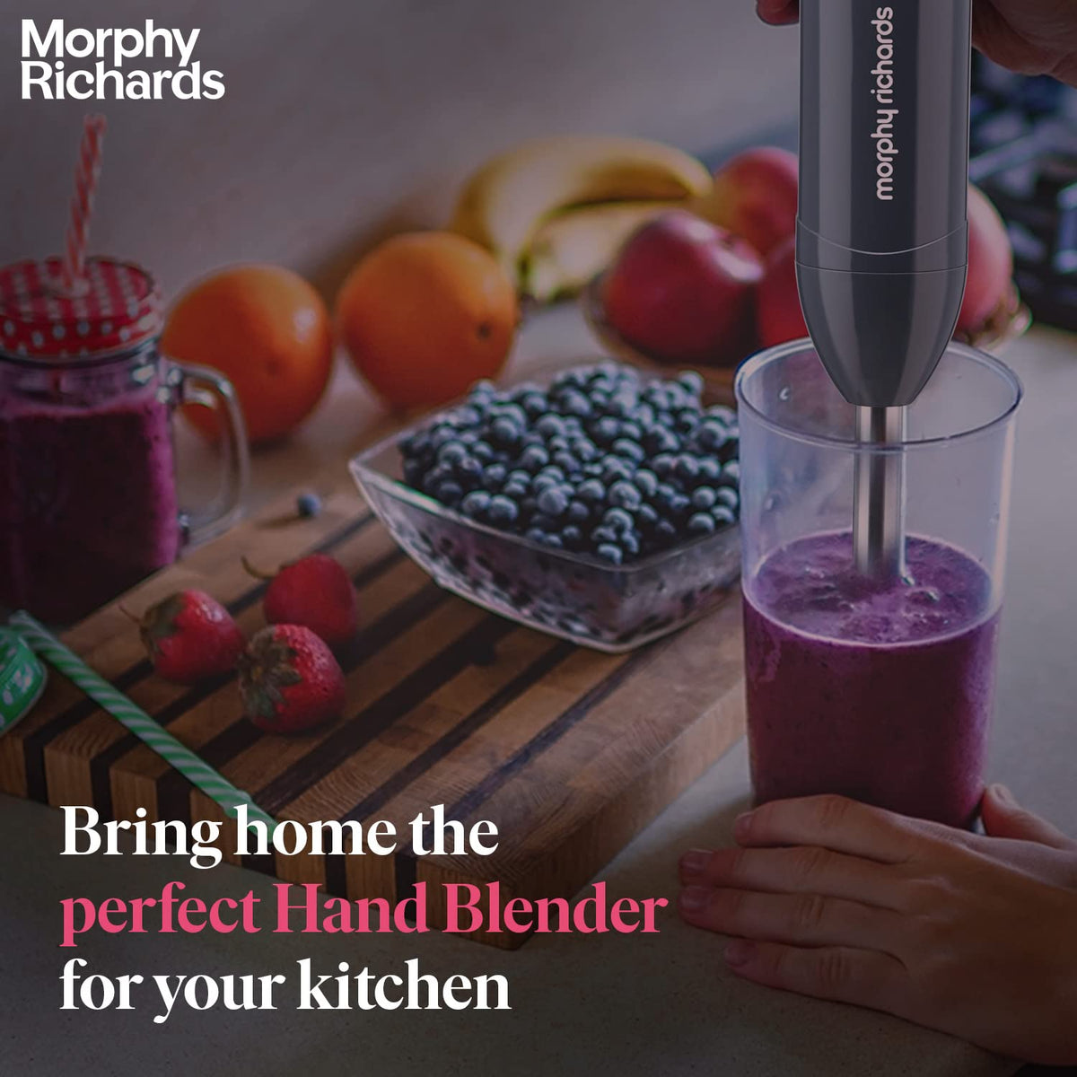 Morphy Richards Pronto Plus hand blender being used to blend a berry smoothie in a tall beaker
