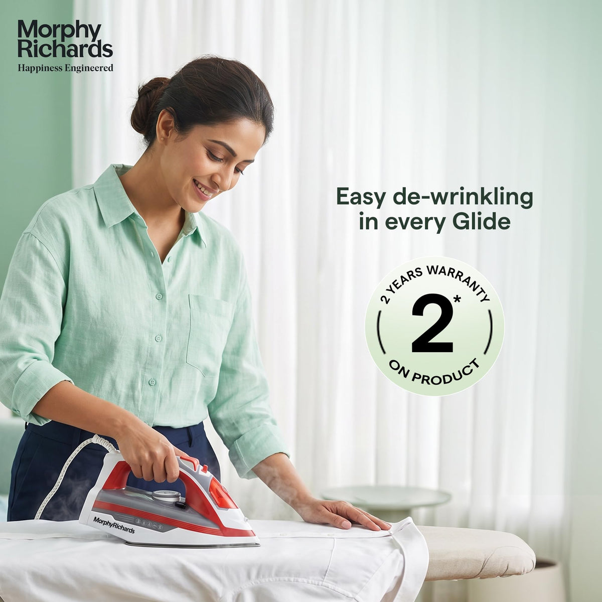 Woman ironing a shirt with the Morphy Richards MR Ultra Glide Steam Iron 1600W, with a 2 years warranty badge