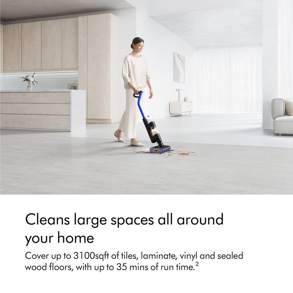Woman using the Dyson WashG1 492608-01 to clean spills on a large hard floor in a bright home