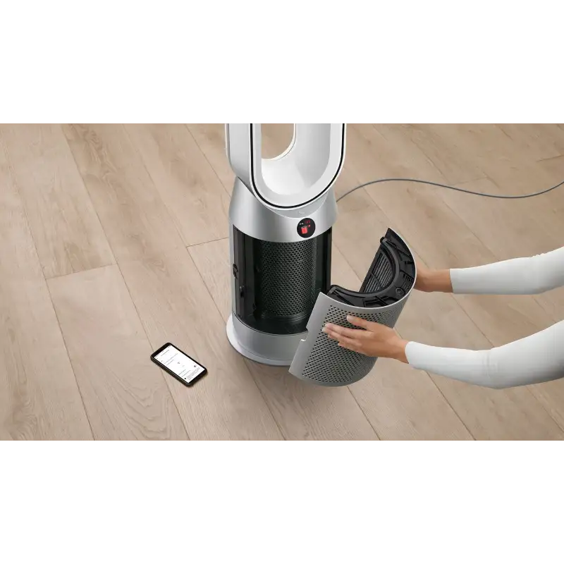 Dyson HP07 Purifier Hot+Cool with the filter panel being removed by hand, with a smartphone beside it on the floor