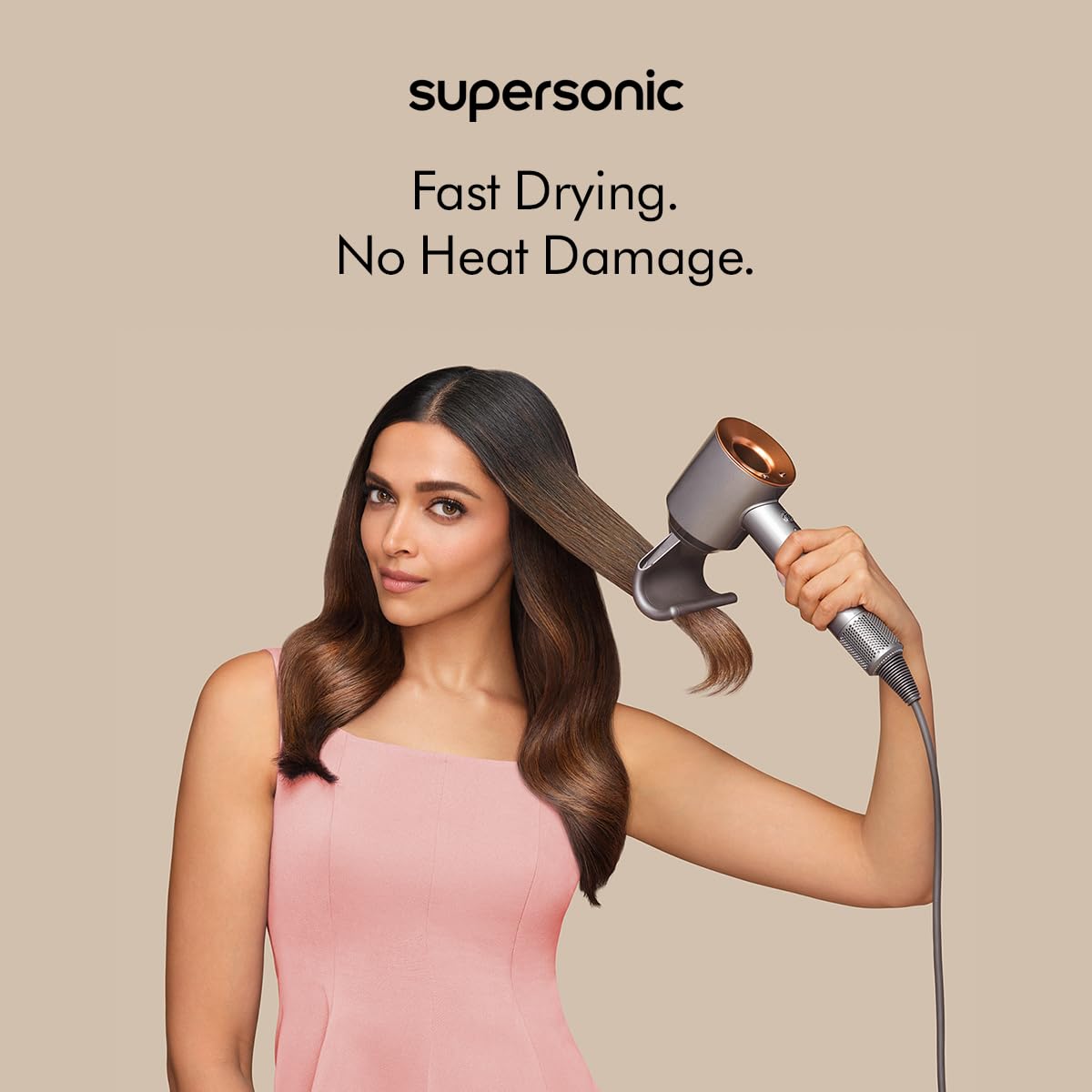 Dyson Supersonic 389934-01 hair dryer with flyaway attachment used on long hair, with the text Fast Drying. No Heat Damage.