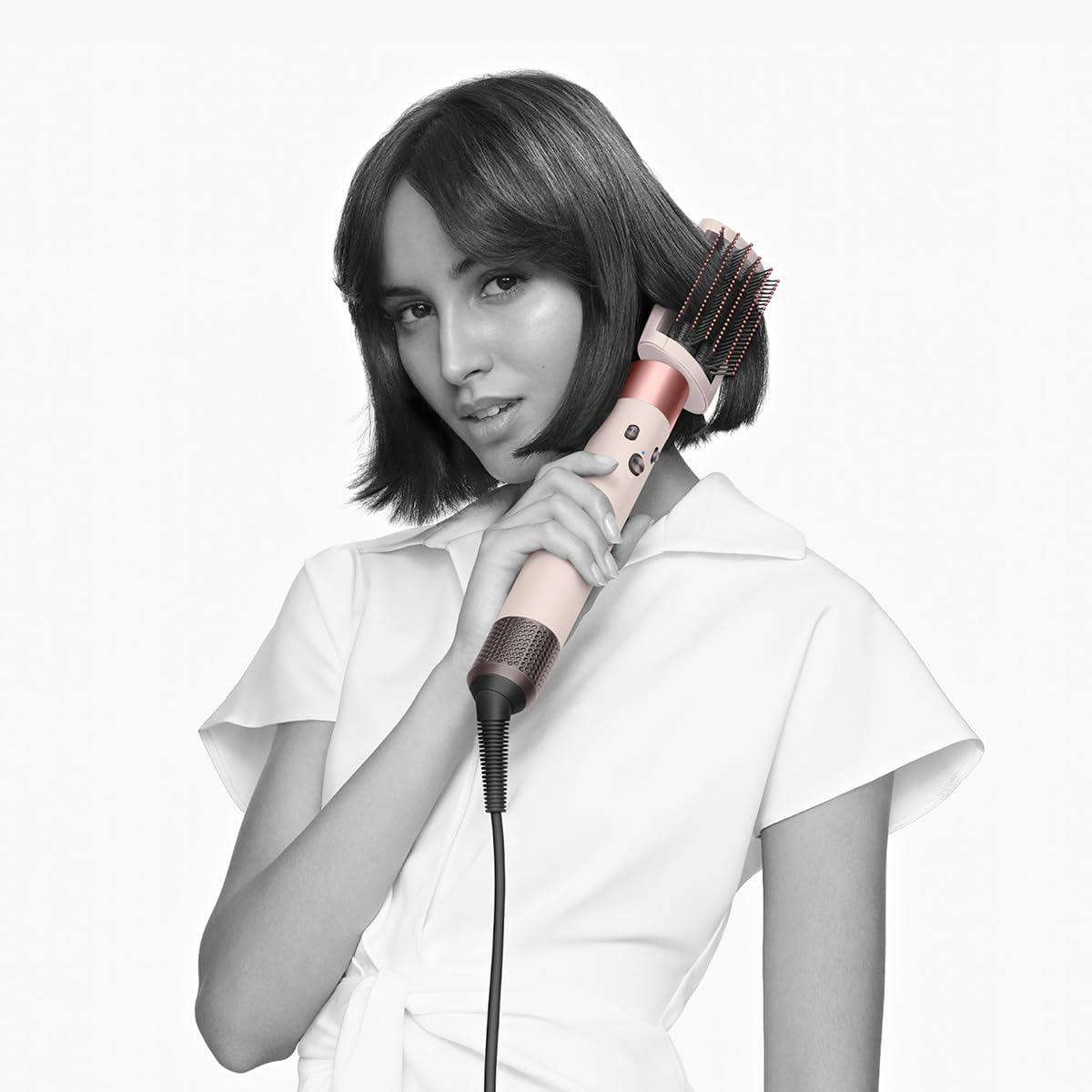 Woman with a bob styling her hair with the Dyson Airwrap 560460-01 fitted with a smoothing brush attachment