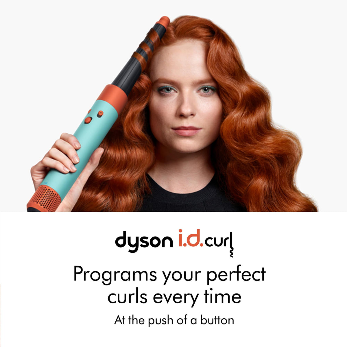 Woman with long auburn waves using the Dyson Airwrap i.d. 533801-01 with a curl barrel, i.d.curl branding below