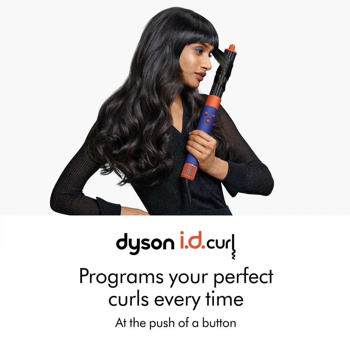 Woman curling long dark hair with a Dyson Airwrap i.d. styler, with i.d.curl text