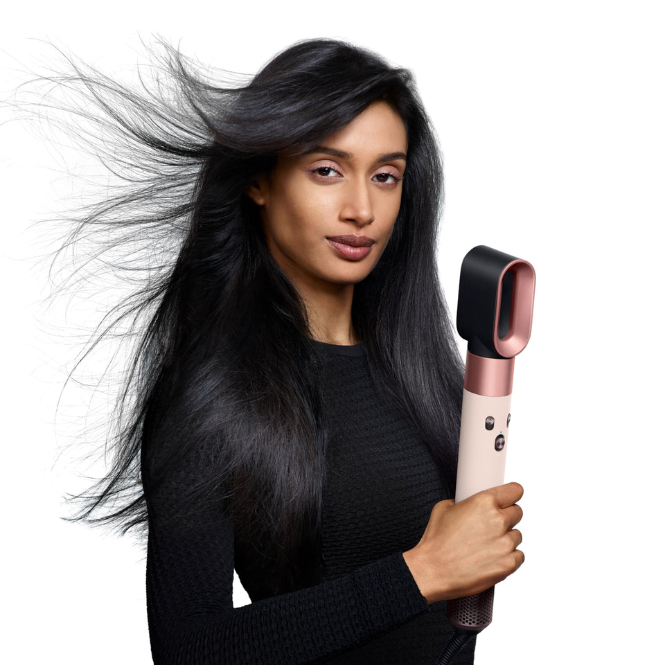 Woman with flowing black hair holding the Dyson Airwrap i.d. 601904-01 with the Dryer attachment fitted