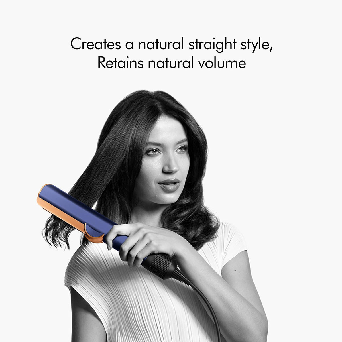 Woman styling her hair with the Dyson Airstrait 408235-01 for a natural straight style with volume