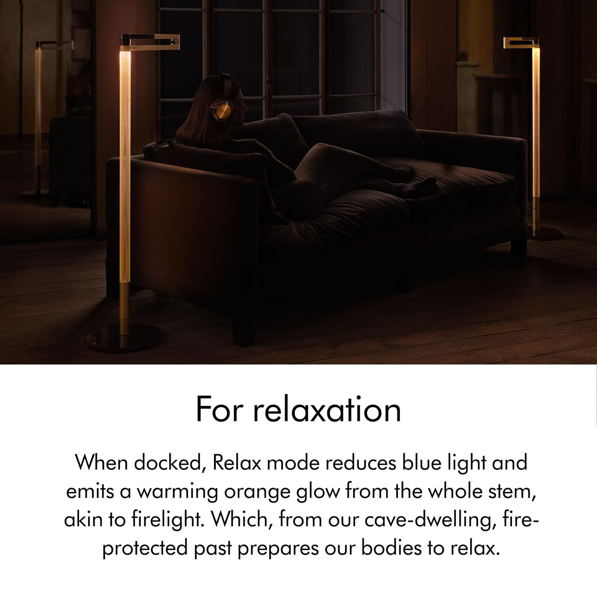 Dyson Solarcycle Morph CF06 floor lights glowing warm orange in Relax mode beside a sofa