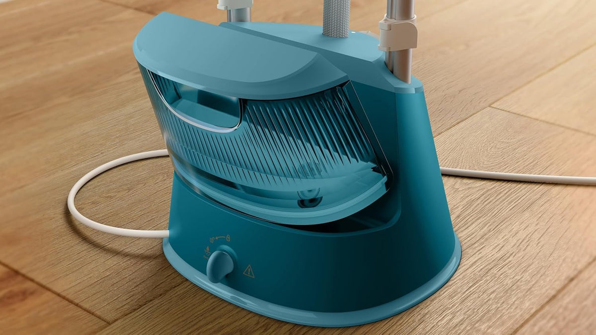 Base of the Philips STE1030/20 garment steamer showing the detachable 1.8 L water tank on a wooden floor