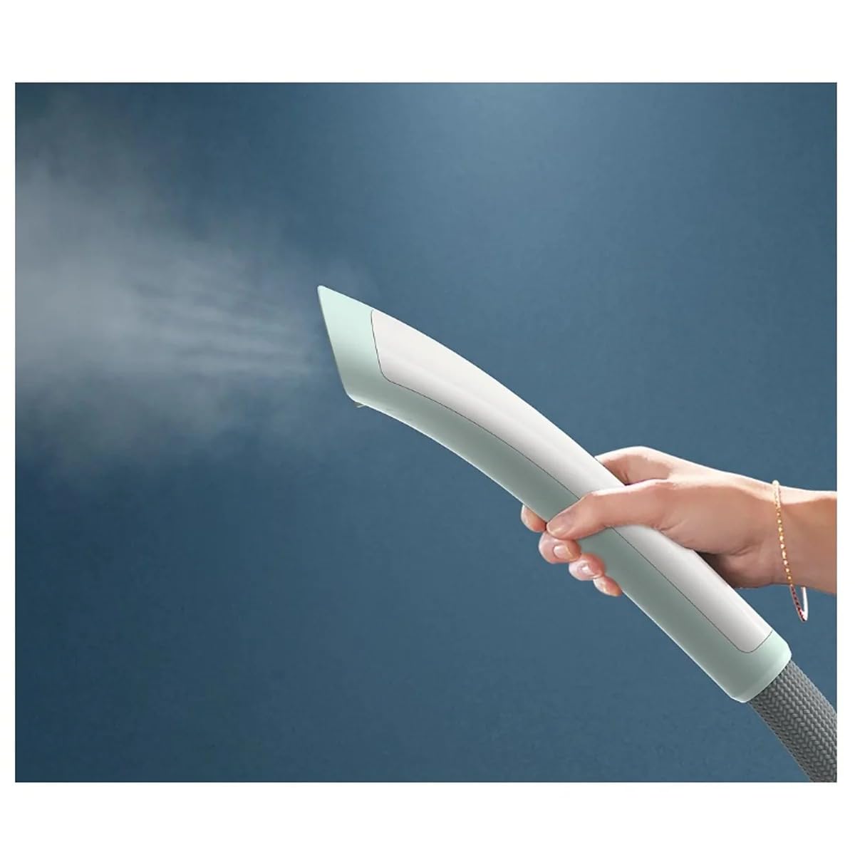 Hand holding the steam head of the Philips STE1010/70 garment steamer with steam being released