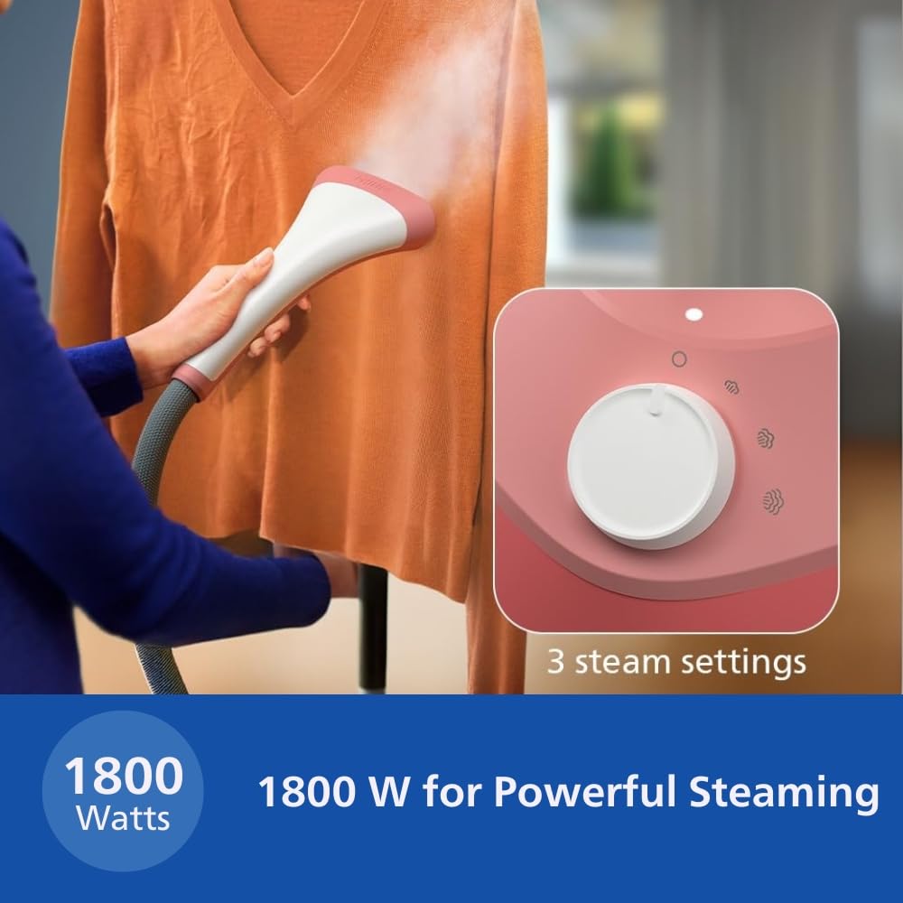 Person steaming an orange jumper with the Philips STE1020/40 handheld steam head, with the 3 steam settings dial shown in an inset