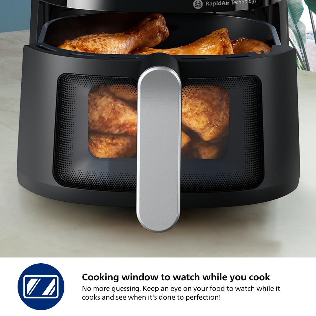 Close-up of the Philips NA221/00 Airfryer cooking window showing chicken drumsticks inside the basket