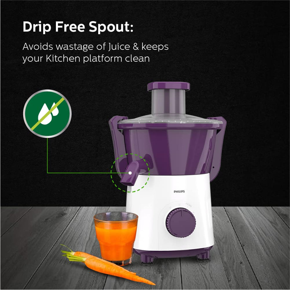 Philips HL7567/01 juicer with drip-free spout, a glass of carrot juice and fresh carrots beside it