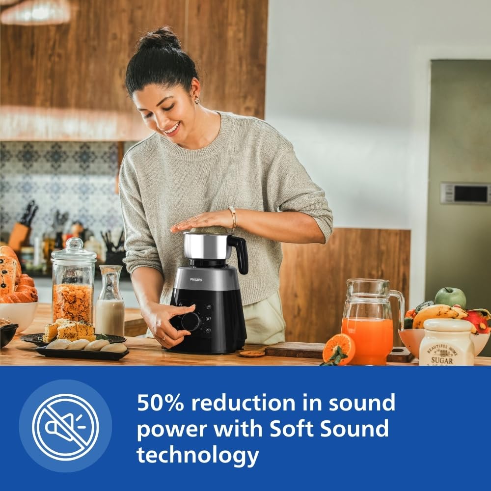 Woman operating the Philips HL7777/00 mixer grinder in a kitchen, highlighting Soft Sound technology