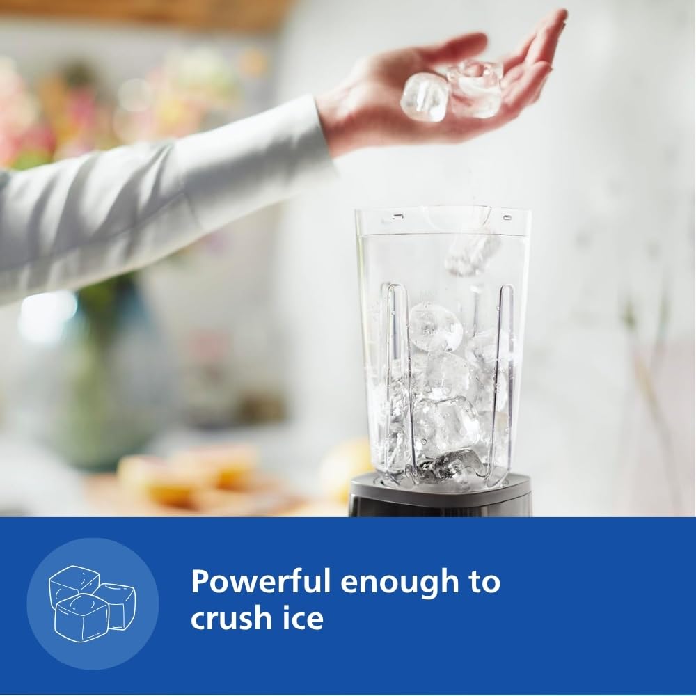 Hand dropping ice cubes into the Philips HR2602/90 blender jar to show ice crushing