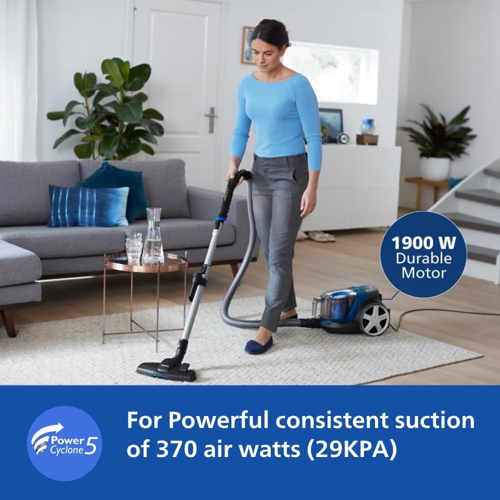 Woman vacuuming a living room rug with the Philips PowerPro FC9352/01, 1900 W motor and PowerCyclone 5 callouts